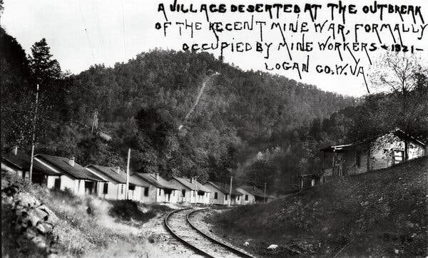 O fotografie din 1921 cu case modeste de-a lungul unor cai ferate.